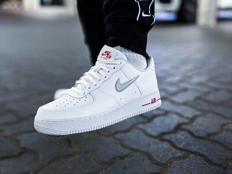 Person trägt weiße Nike Air Force 1