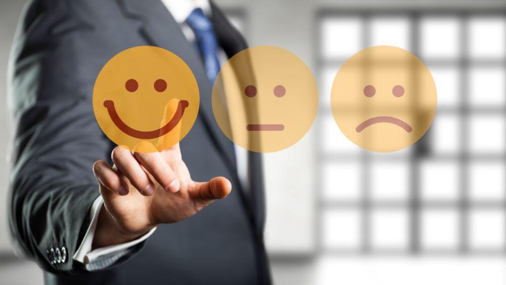 Geschäftsmann wählt lächelnden Smiley vor Bürohintergrund