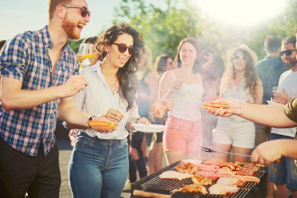 Paar steht und trinkt Alkohol bei einer Grillparty