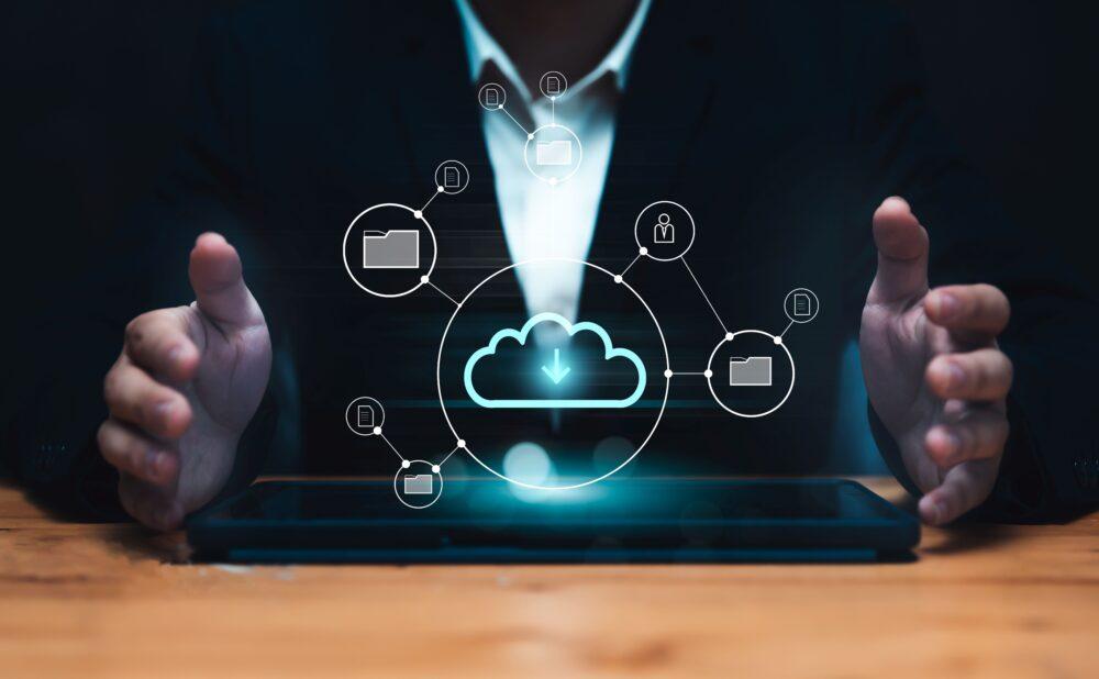 Mann in Anzug mit Tablet, über dem eine digitale Cloud mit vernetzten Symbolen