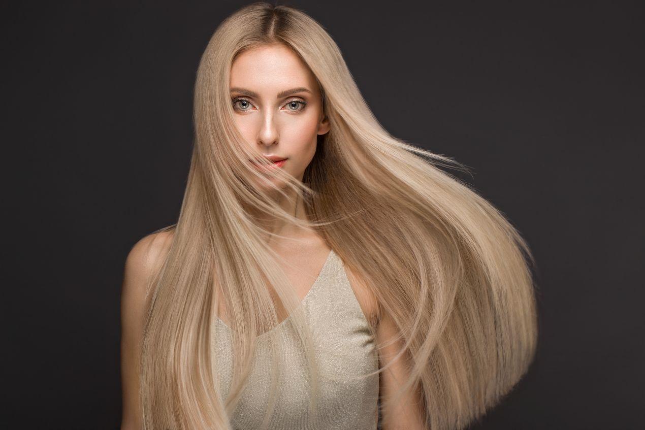 Frau mit glattem, langem, blondem Haar – idealer Einsatzbereich fuer Clip In Extensions zur Haarverlaengerung und Strukturveredelung.