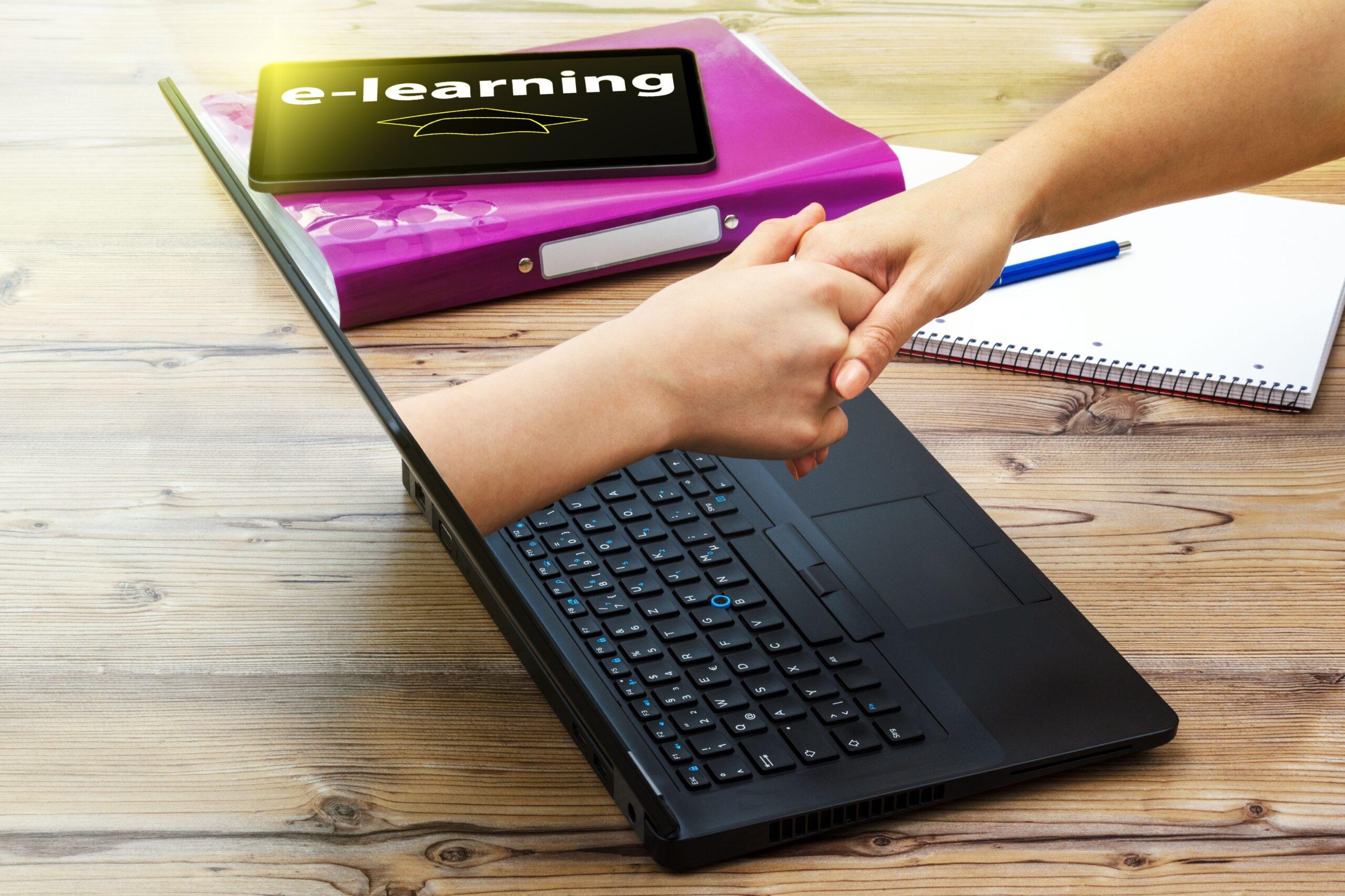 Eine Person reicht sich die Hand mit einer imaginären Hand, welche aus einem Laptop Bildschirm gereicht wird