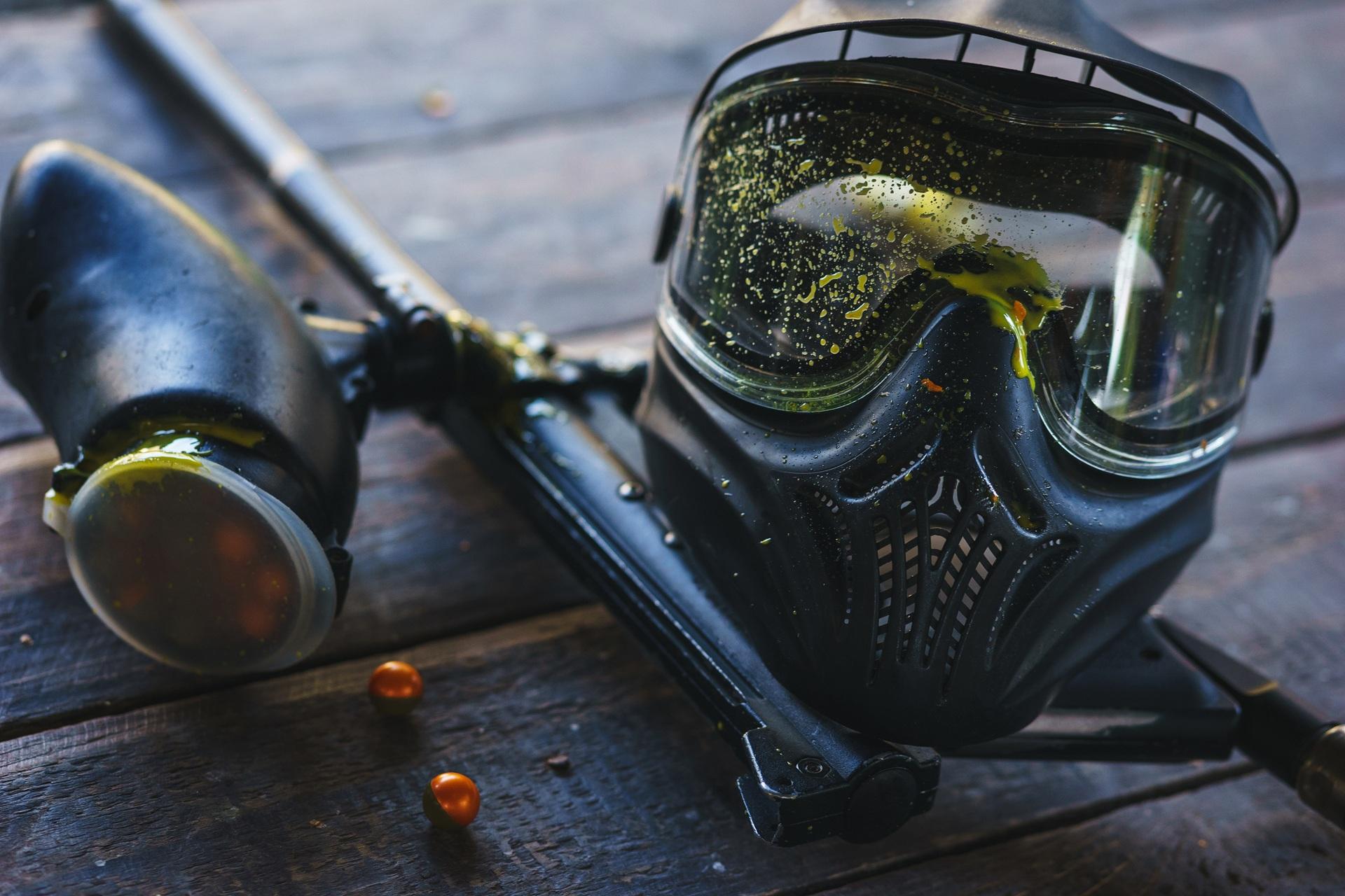 Paintball-Maske und Markierer mit Farbspritzern | Softair