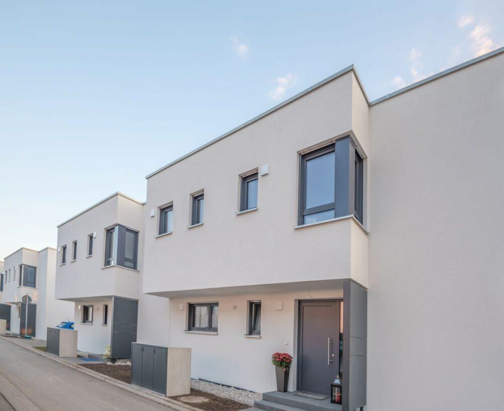Mülltonnenbox Metall vor einem modernen Reihenhaus mit klarer Architektur und dezentem Design