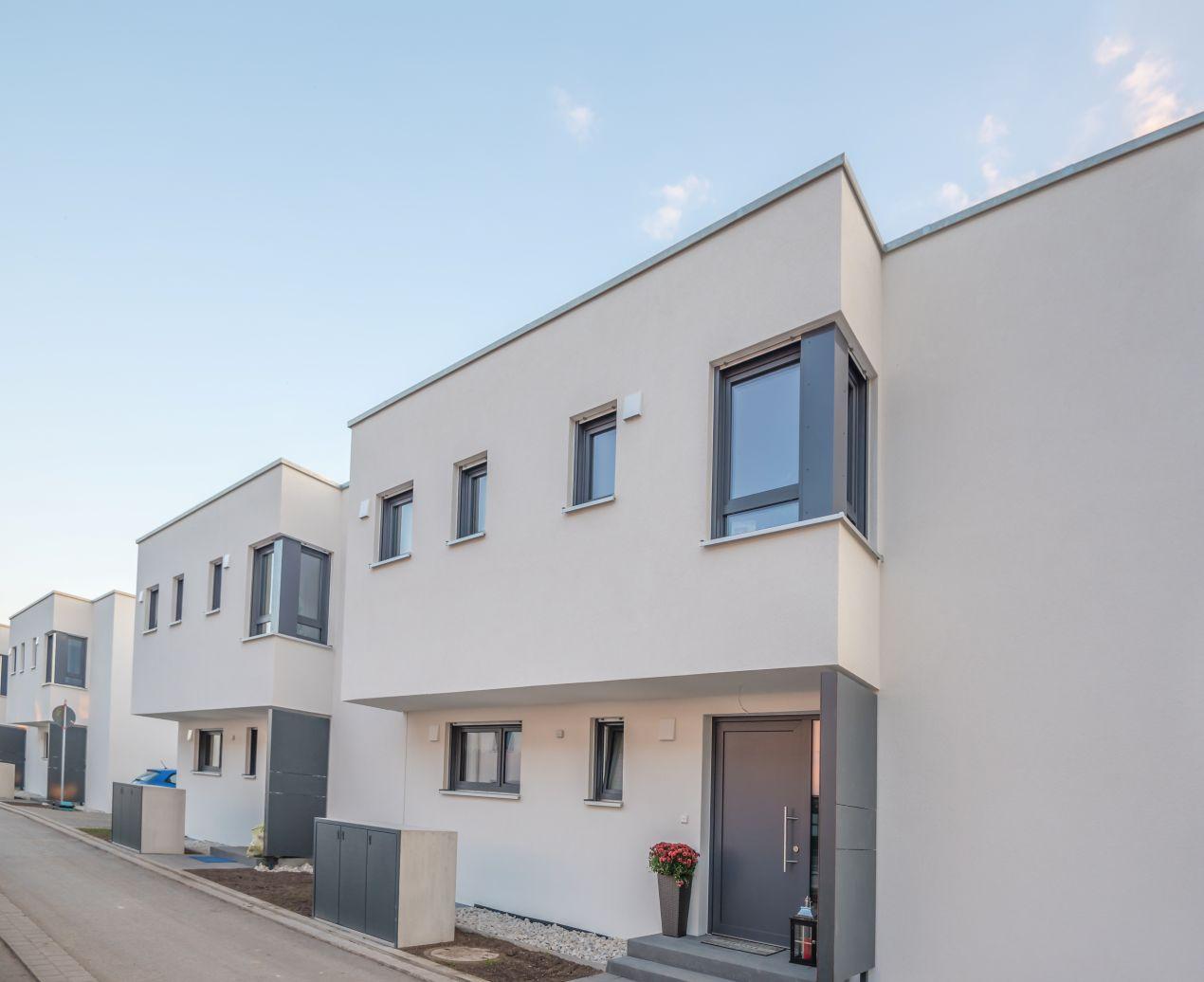 Mülltonnenbox Metall vor einem modernen Reihenhaus mit klarer Architektur und dezentem Design