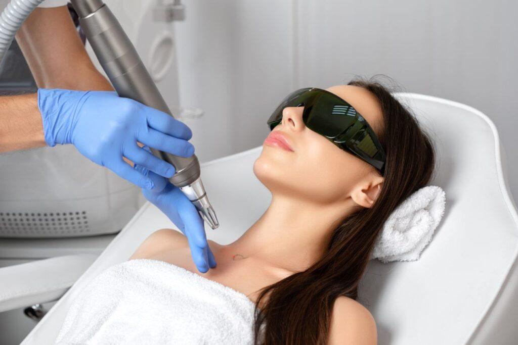 Tattooentfernung Düsseldorf: Frau bei professioneller Laserbehandlung mit Schutzbrille im Institut